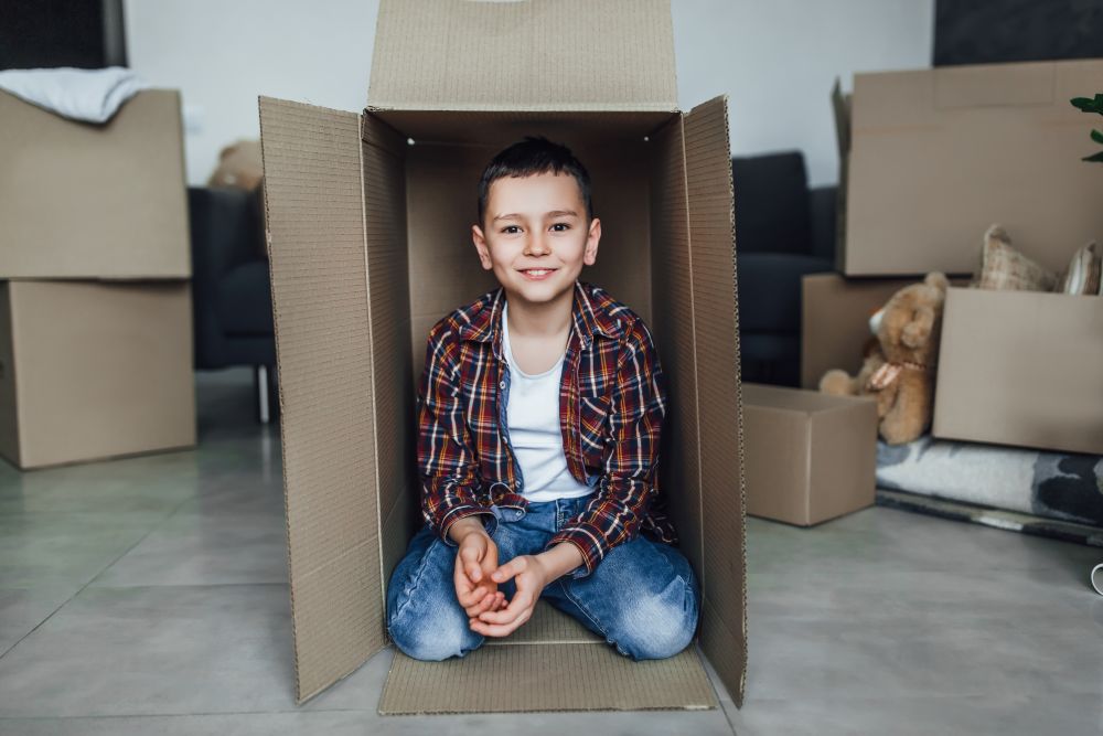 Enfant utilisant son imagination pour transformer des boîtes en carton en un vaisseau spatial.